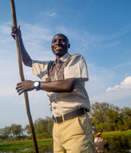 Khwai Expeditions Camp a man poling a traditional mokoro canoe in Khwai